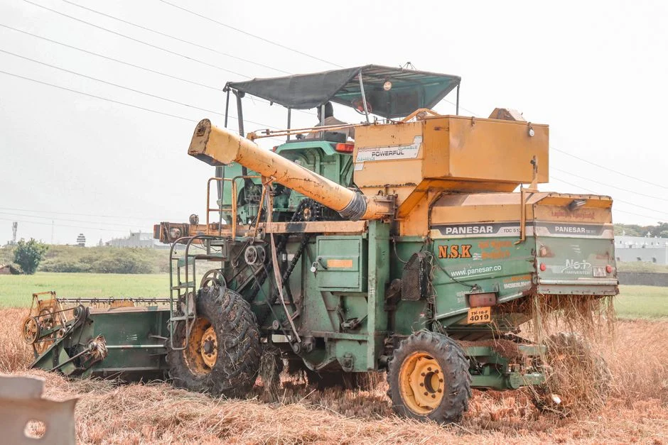 Combine harvester working a grain field on large drive wheels