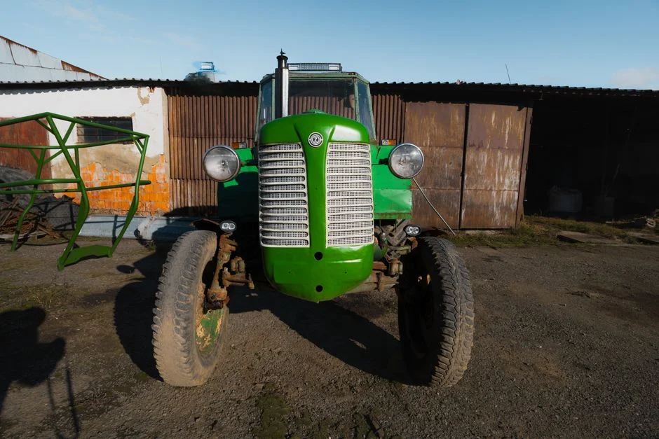 Front wheel and tire of a vintage green tractor on a farm