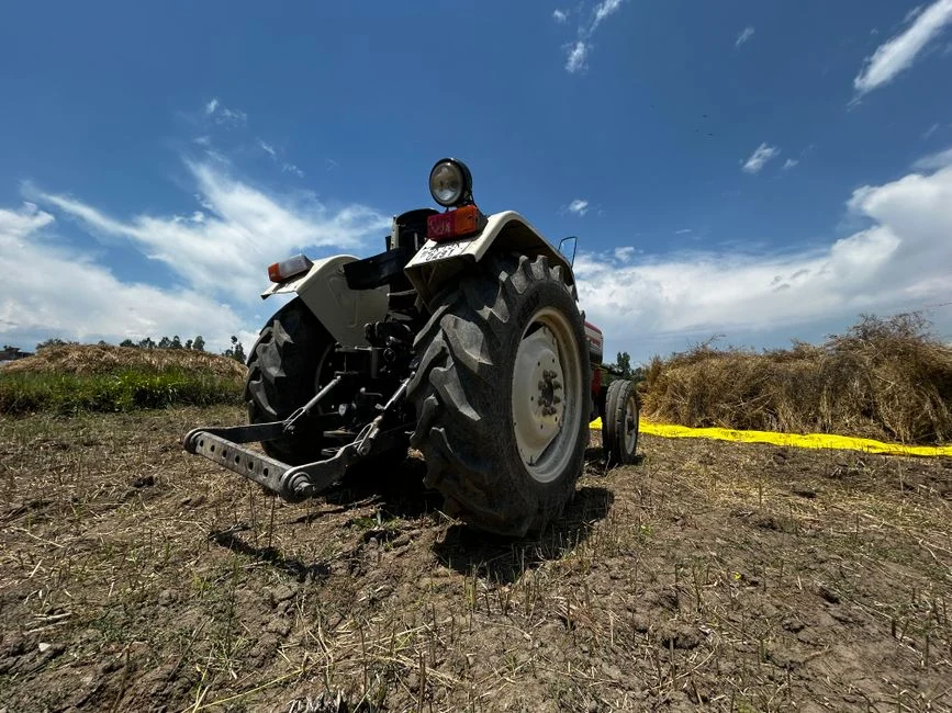 Low angle view of a tractor in a harvested field on a sunny day
