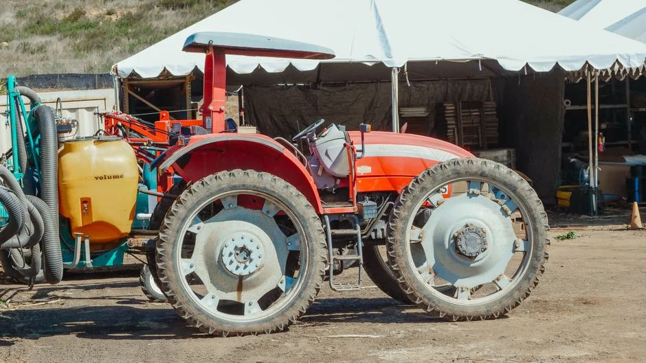 Close-up of a red tractor parked on a farm
