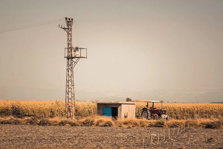 A tractor in a rural landscape with crops