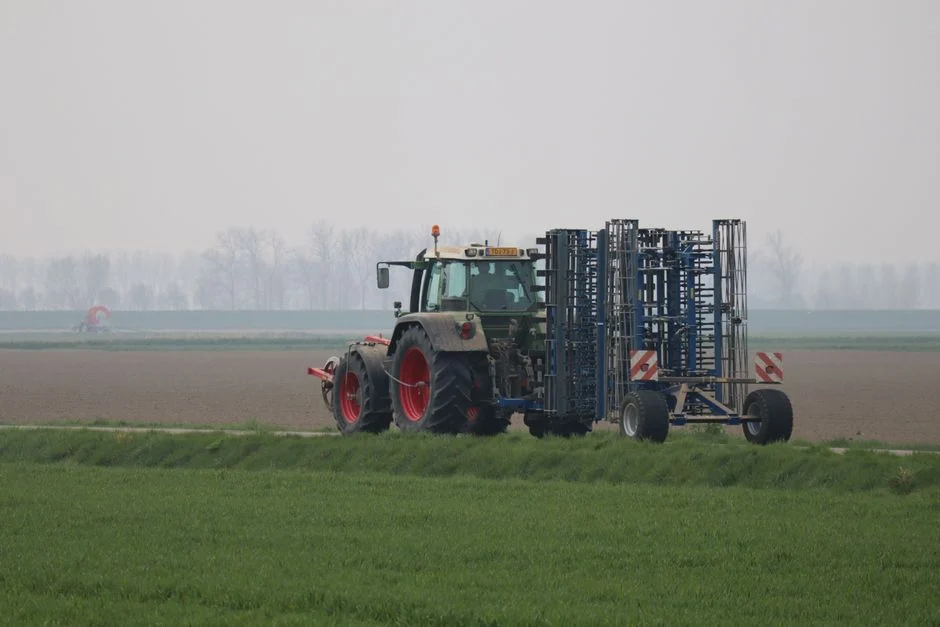 A tractor working on farmland on an overcast day