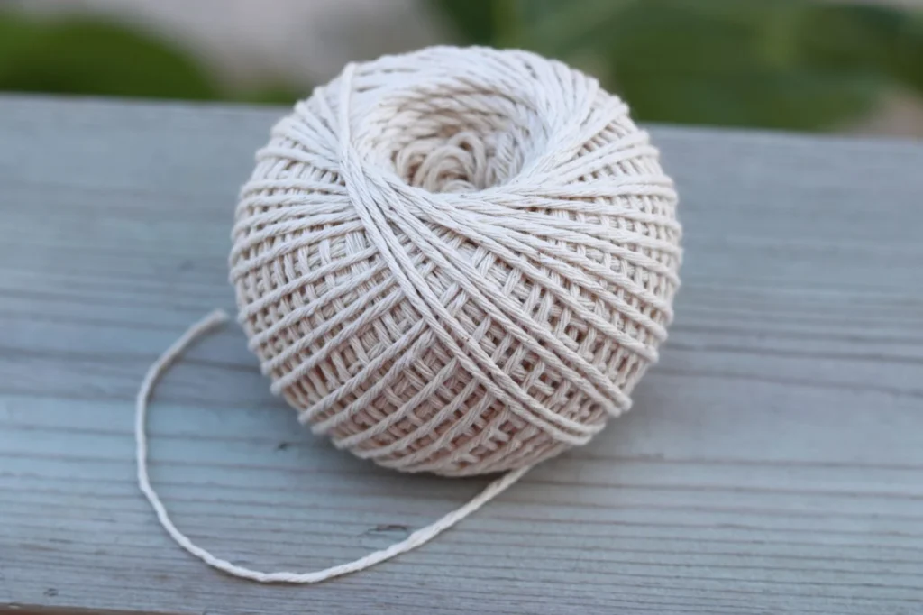 Cream-colored ball of twine resting on a wooden surface