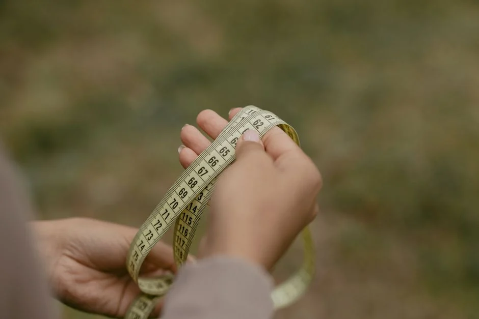Hands holding a rolled measuring tape