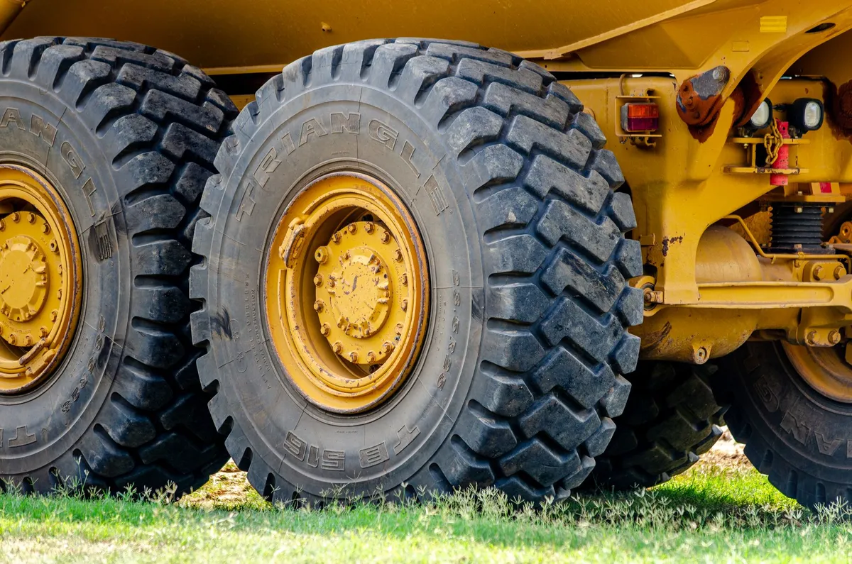 Front Tractor Tires: Which Tread, Size and Pair to Buy Close-up view of large industrial truck tires in an outdoor setting, showcasing heavy equipment and rugged design.