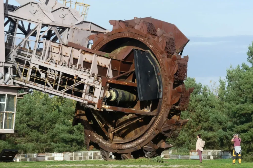 Close-up of a large industrial machine wheel and tire at an outdoor site