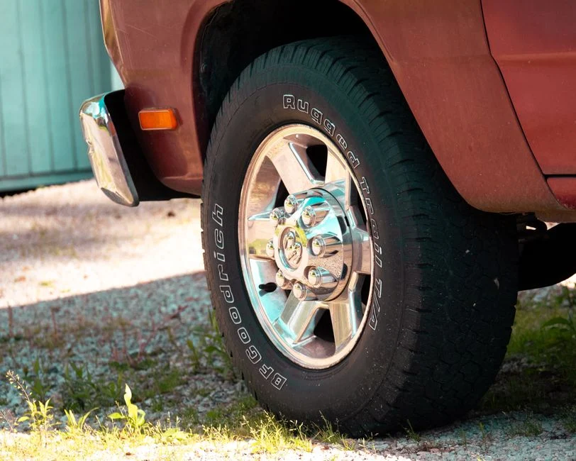 light truck wheel and tire resting on gravel