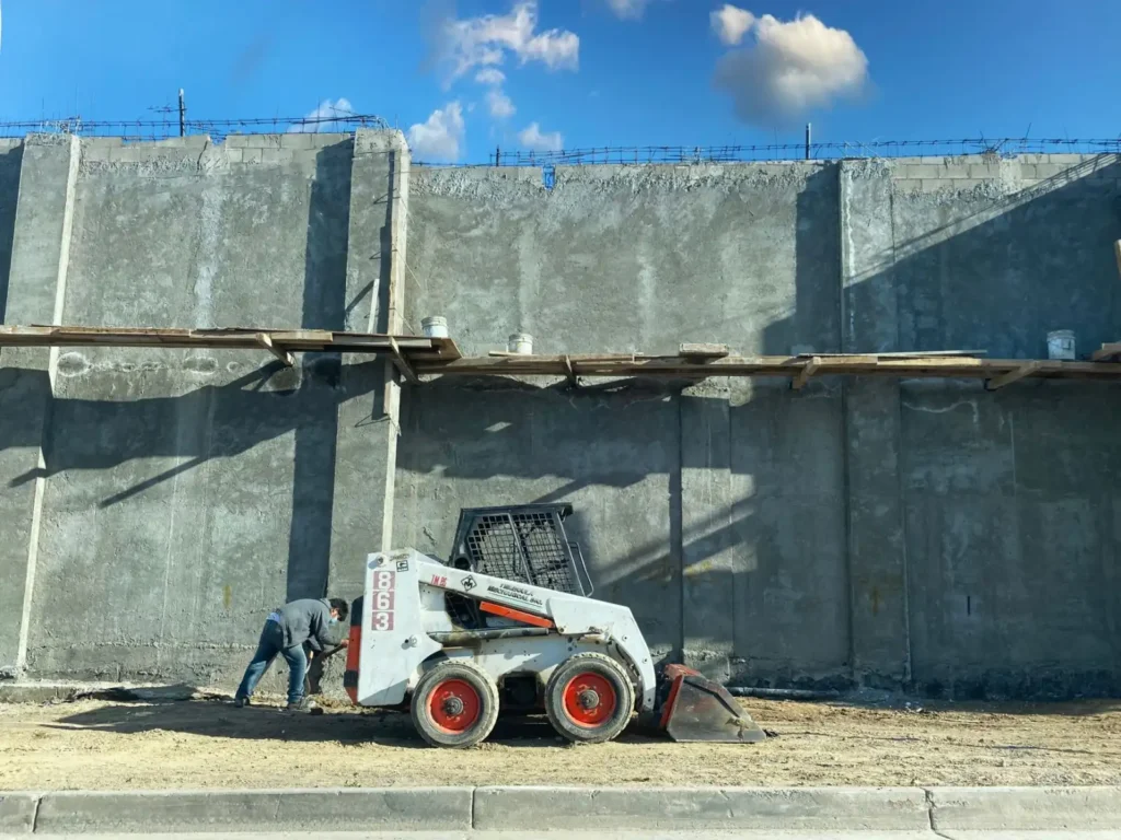 Worker operating a loader at a concrete construction site