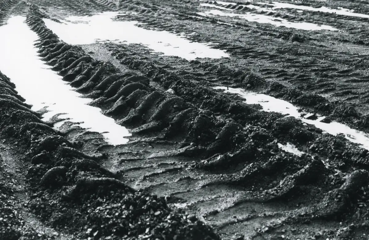 Rear Tractor Tires: Sizes, Tread and How to Pick a Pair Detailed close-up of muddy tire tracks filled with water, capturing texture and patterns.