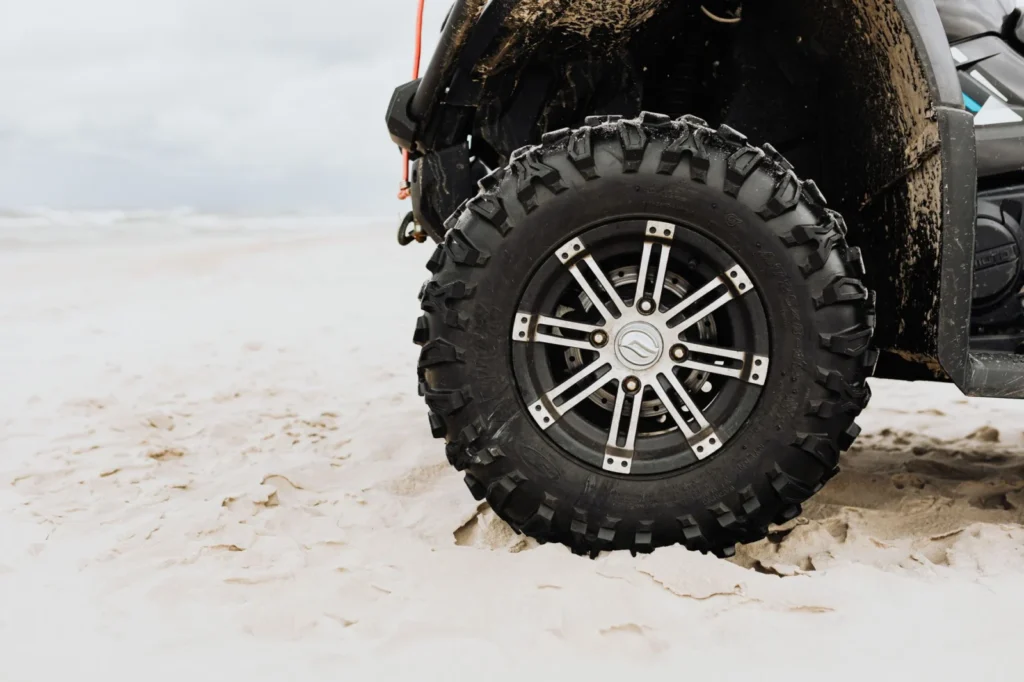 Close-up of a lugged off-road tire tread on sand