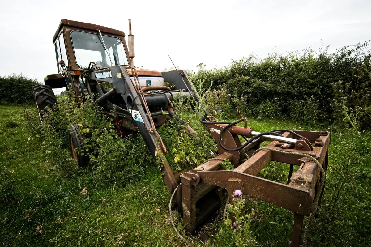 Front Tractor Tires: Which Tread, Size and Pair to Buy An old, overgrown tractor sits unused in a lush green field in England.