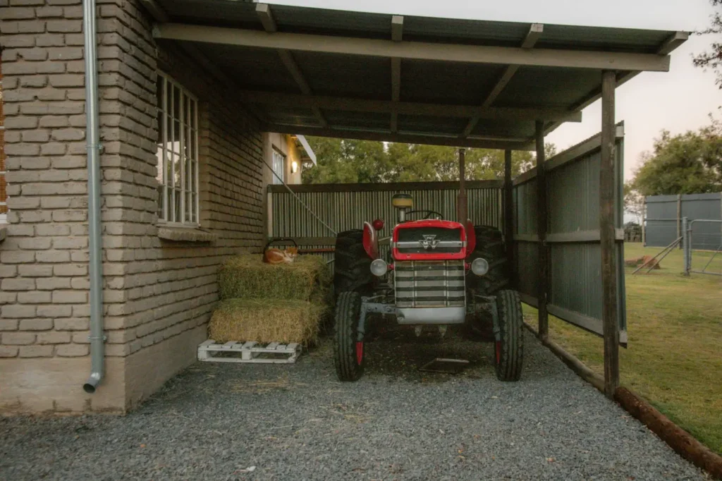 Firestone Tractor Tires: Who Makes Them and Which Line Fits Old tractor parked under a rustic shed beside hay bales