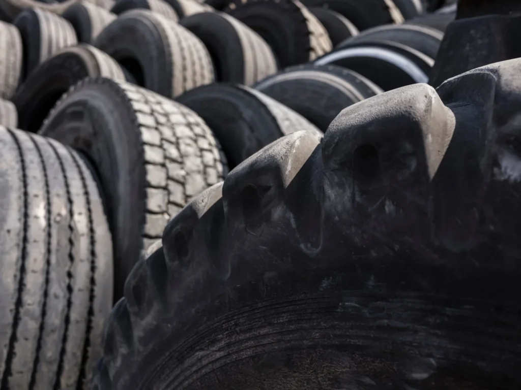 Pile of used tires stacked outdoors in an industrial yard
