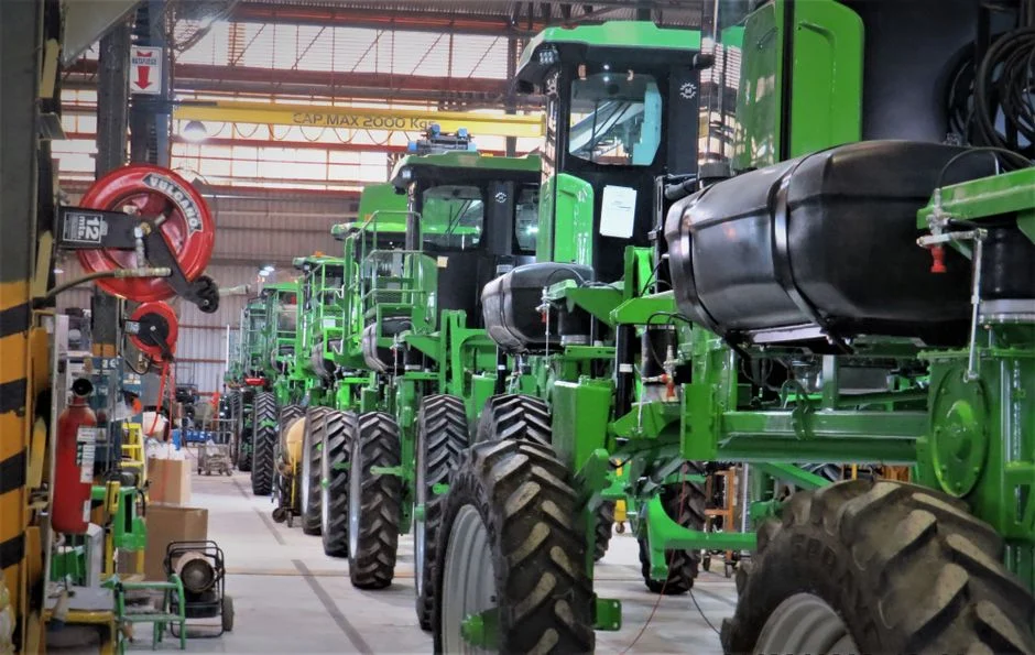 Line of green agricultural machines inside a warehouse in Cascavel, Brazil