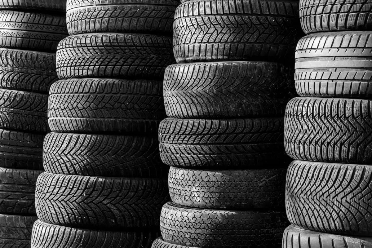 Firestone Tractor Tire Size Chart: Every Size by Model Black and white image of stacked vehicle tires showcasing various tread patterns.