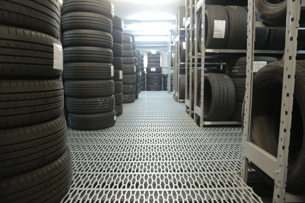 Rows of stacked tires on racks in an indoor warehouse