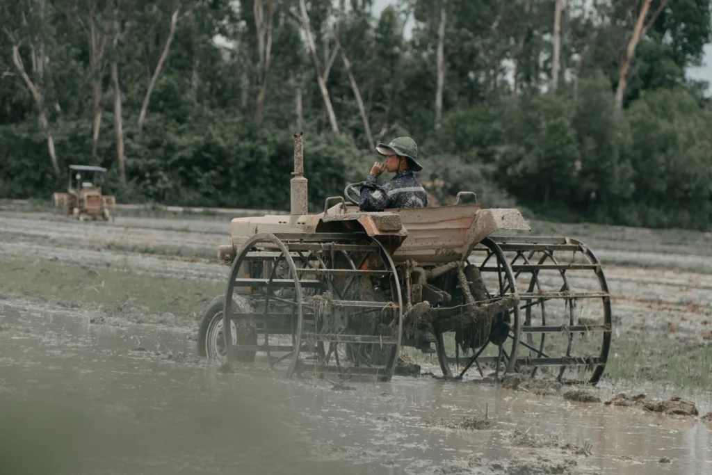 R3 Tires: What They Are, Where They Work and When They Don't Farmer driving a tractor through a muddy field with trees behind
