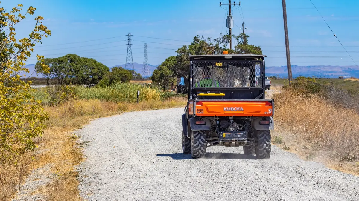 Front Tractor Tires: Which Tread, Size and Pair to Buy Tractor driving along a dirt road in the countryside on a sunny day.