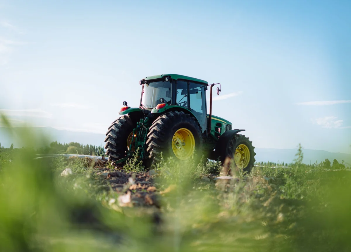 Firestone Tractor Tire Size Chart: Every Size by Model A tractor sits in a vineyard field under a clear sky in Mendoza, Argentina, highlighting rural agriculture.