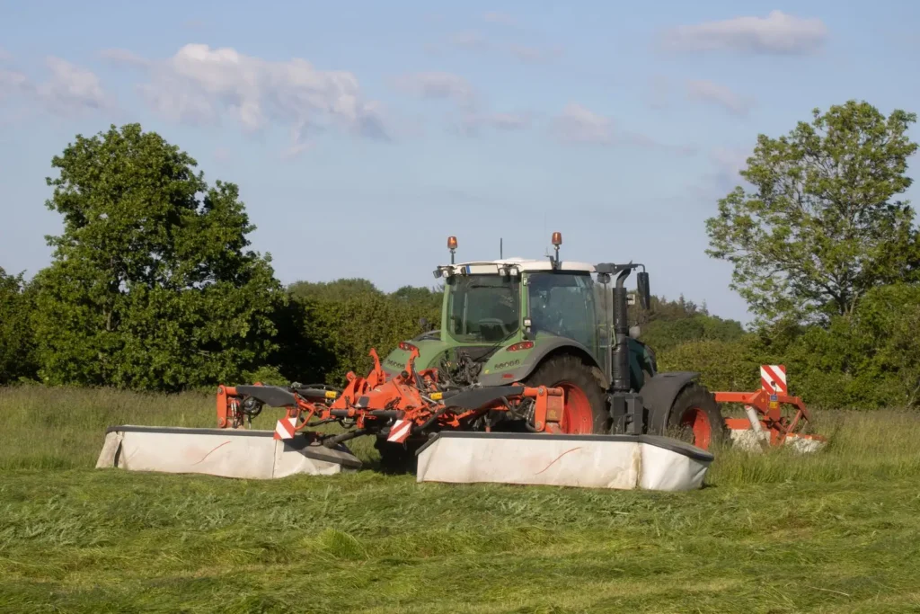 Modern tractor mowing a green field on a sunny day