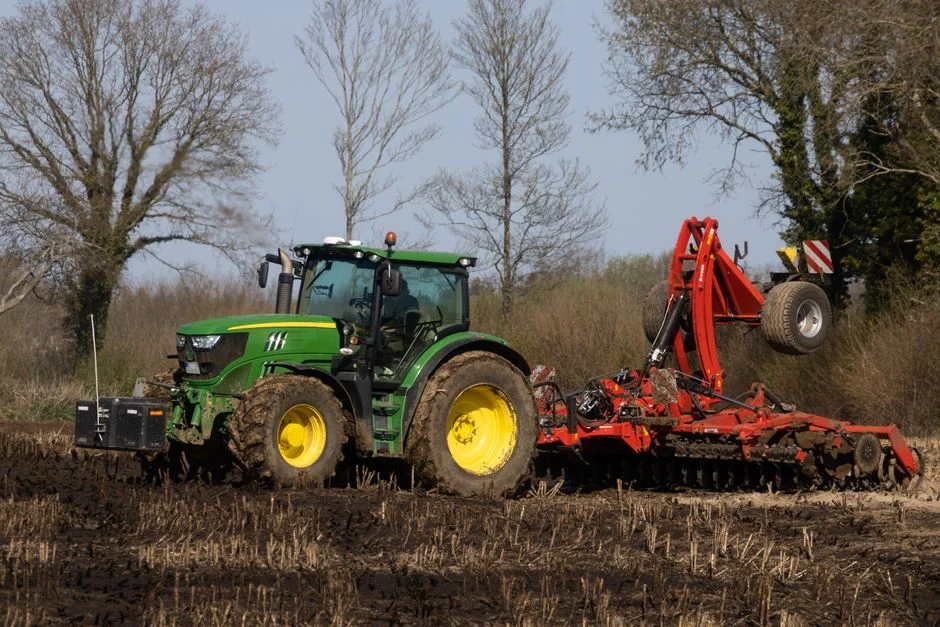 A tractor plowing a field to prepare the soil for planting