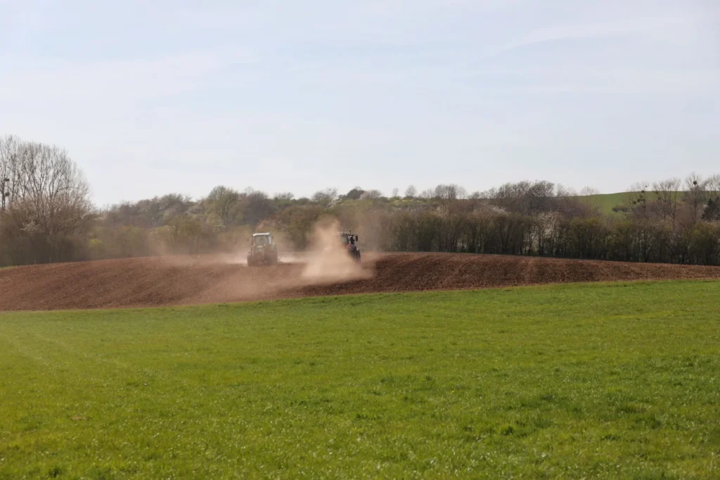 Tractor plowing a field under a clear blue sky in spring