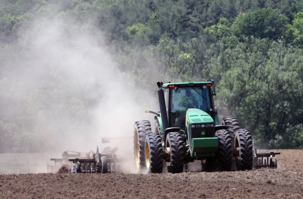Tractor Tire Size Guide: How to Read Every Number on the Sidewall Tractor on radial tires pulling a tillage implement through a dusty field