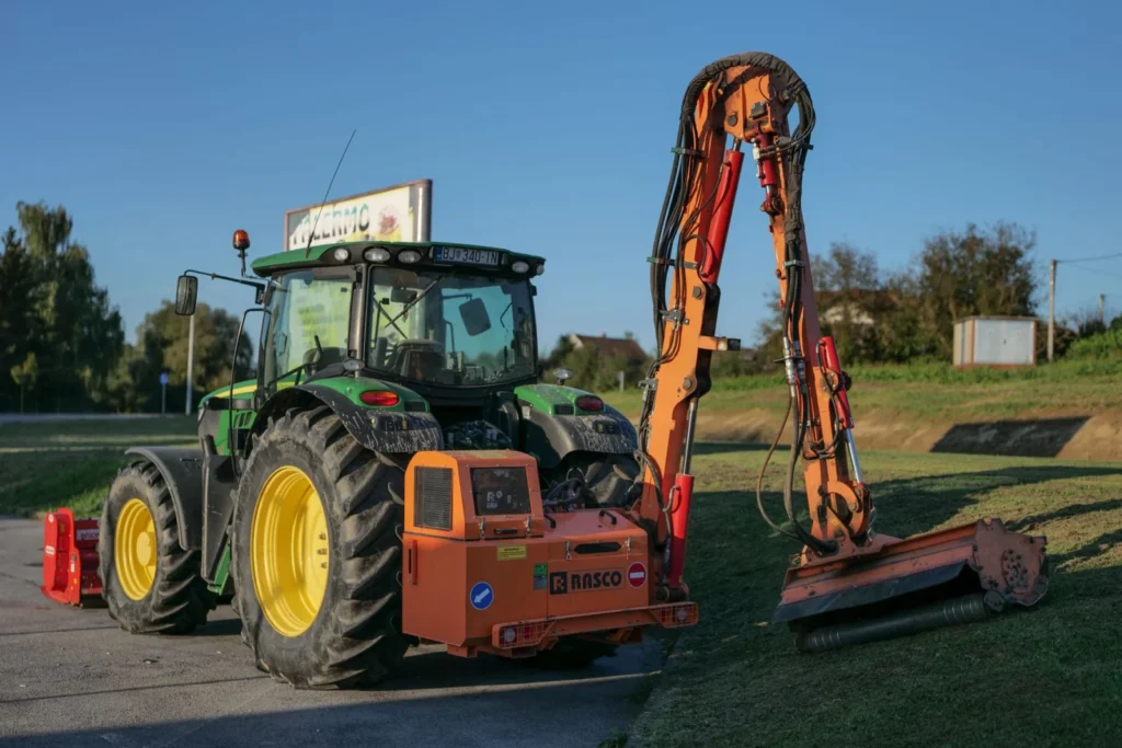Tractor with a mower attachment cutting grass in a rural field