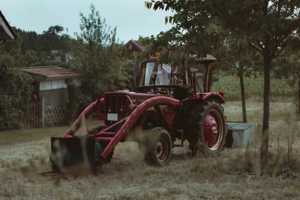 Firestone Tractor Tires: Who Makes Them and Which Line Fits Vintage red tractor sitting idle on a quiet farm field