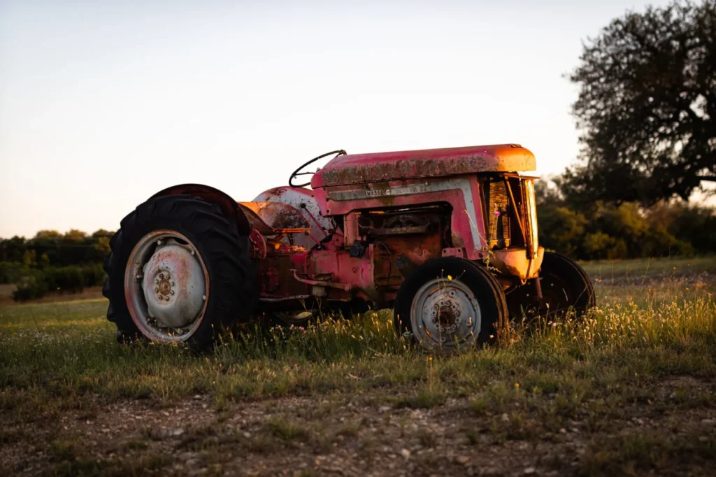 DOT Tractor Tires: How to Read the Date Code and Tire Age Vintage rusty tractor in a grass field at sunset
