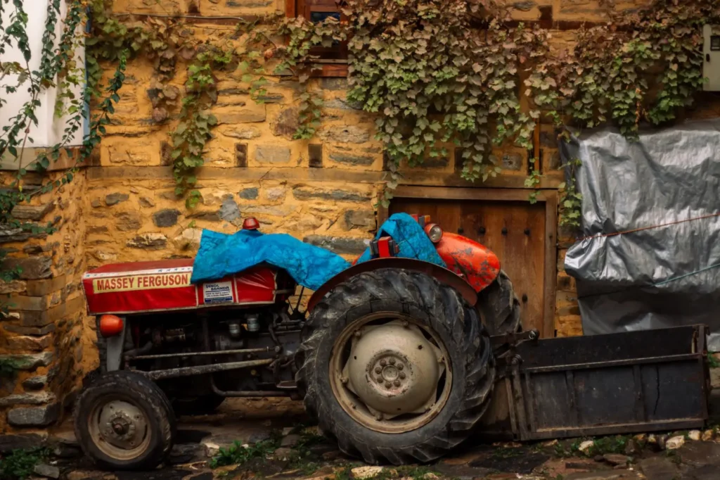DOT Tractor Tires: How to Read the Date Code and Tire Age Weathered Massey Ferguson tractor parked against an ivy-covered stone wall