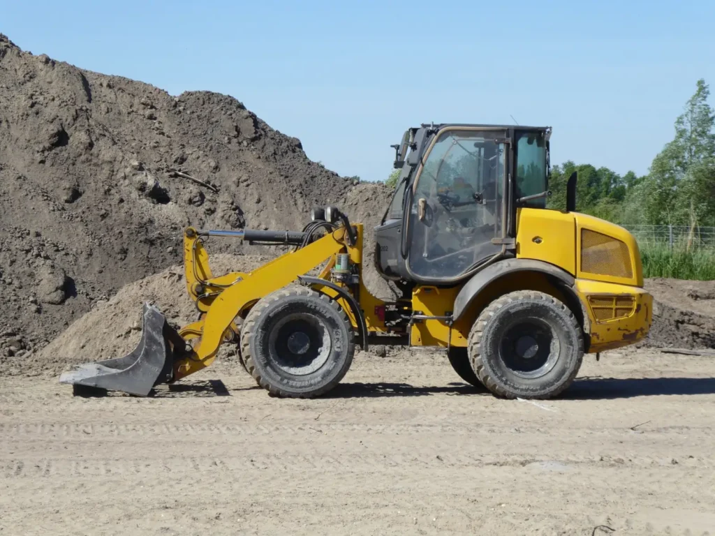 Yellow loader on a construction site beside dirt mounds