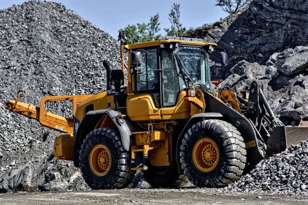 Yellow construction loader moving gravel at a quarry site