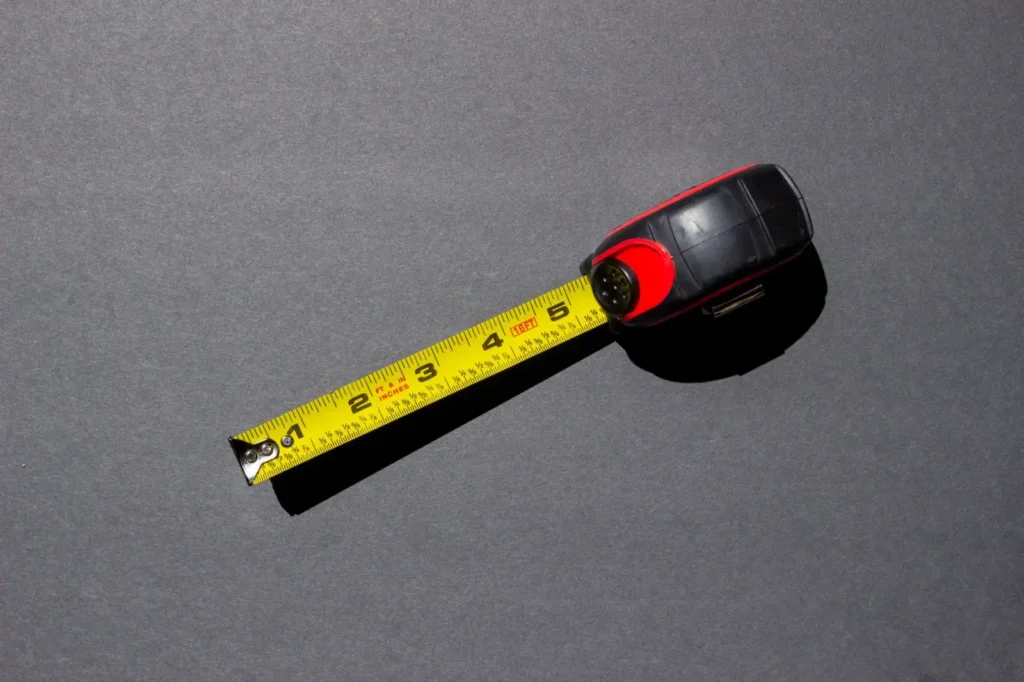 Yellow tape measure lying on a dark surface