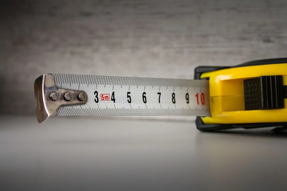 Yellow tape measure extended on a plain surface